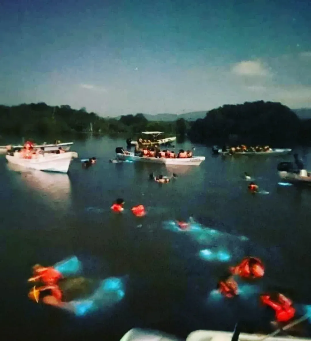 Wide view of Chacahua Lagoon with boats and swimmers