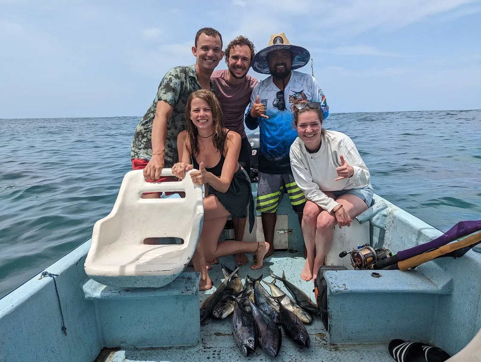 Friends celebrating their catch on fishing boat in Pacific Ocean