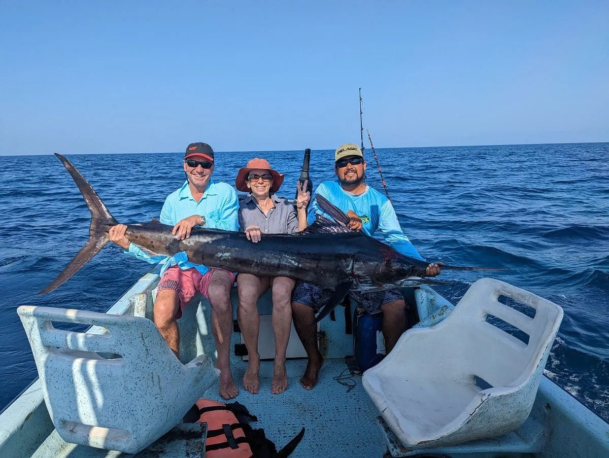 Couple with guide holding impressive marlin catch