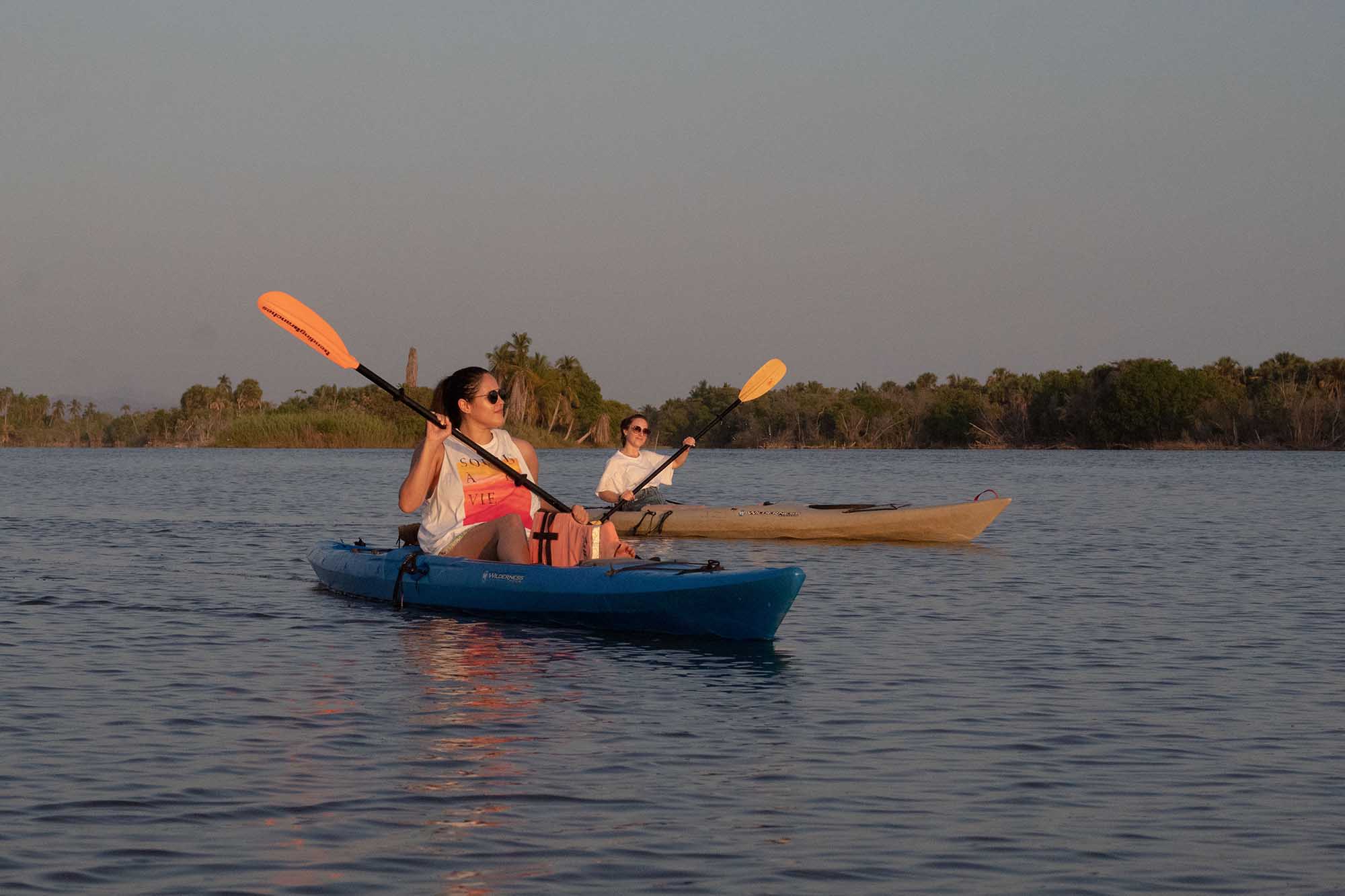 Two kayakers enjoying sunset paddle on Manialtepec Lagoon